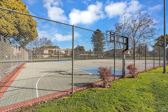 view of basketball court with community basketball court, a yard, and fence