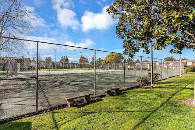 view of sport court featuring a lawn and fence