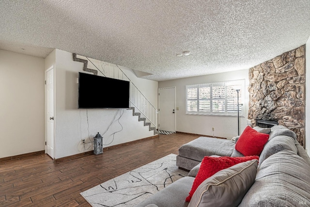 living area with stairway, wood-type flooring, a textured ceiling, and baseboards