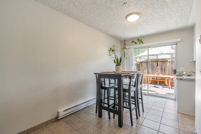 dining space featuring light tile patterned floors, baseboard heating, a textured ceiling, and a textured wall