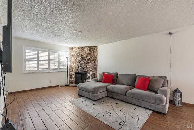 living room with baseboards, a textured ceiling, wood finished floors, and a fireplace