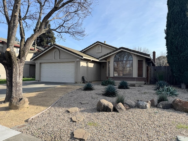 ranch-style home with stucco siding, driveway, a garage, and fence