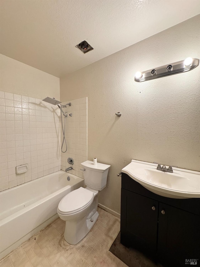 bathroom with washtub / shower combination, toilet, vanity, tile patterned floors, and a textured ceiling