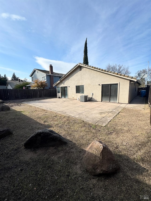 back of house featuring stucco siding, cooling unit, and a fenced backyard