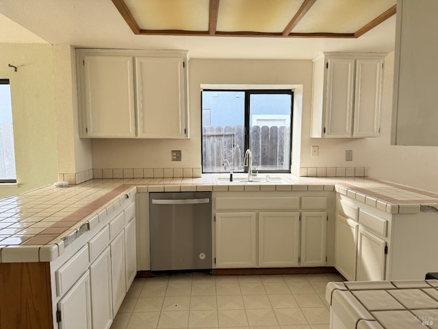 kitchen featuring tile countertops, dishwasher, white cabinets, and a sink