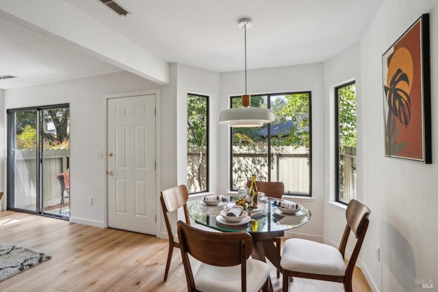 dining area featuring light wood-type flooring, baseboards, and visible vents