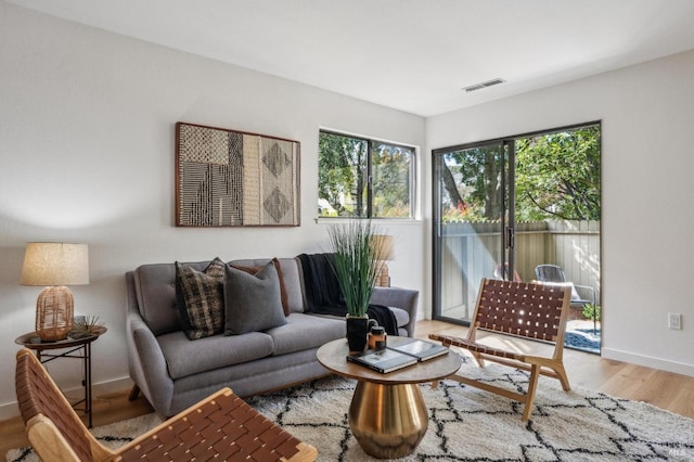 living area with visible vents, baseboards, and wood finished floors