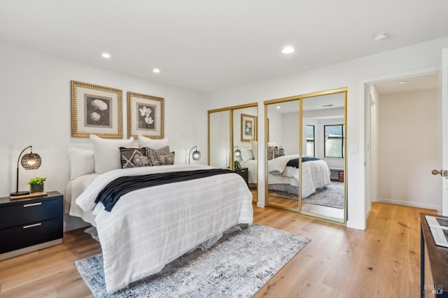 bedroom with recessed lighting, two closets, and light wood-type flooring