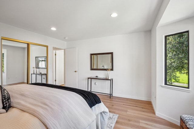 bedroom with recessed lighting, light wood-type flooring, and baseboards