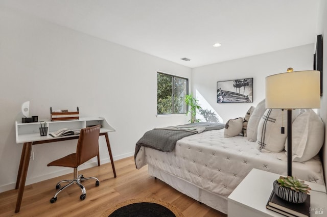 bedroom with recessed lighting, visible vents, baseboards, and wood finished floors