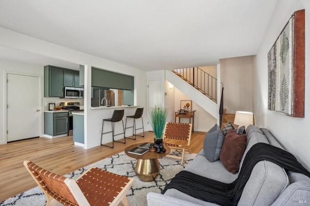 living room featuring stairway and light wood finished floors