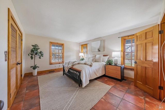 bedroom featuring tile patterned flooring, visible vents, and baseboards