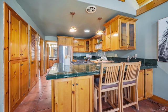 kitchen with visible vents, a peninsula, stainless steel appliances, and glass insert cabinets