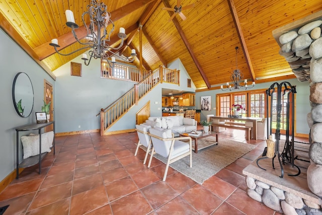 living room featuring beamed ceiling, plenty of natural light, a notable chandelier, and stairs