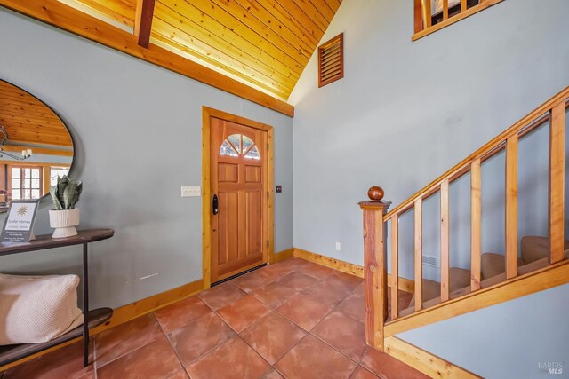 foyer with tile patterned flooring, stairway, wood ceiling, and baseboards