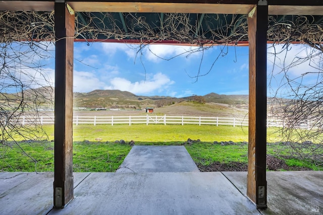 view of patio featuring a mountain view, a rural view, and a fenced backyard