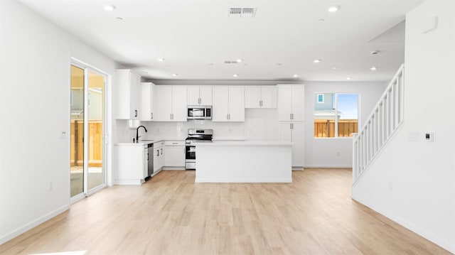 4040 Molten Creek Way, Roseville, CA 95747 - kitchen with appliances with stainless steel finishes, backsplash, light wood-style floors, light countertops, and white cabinets