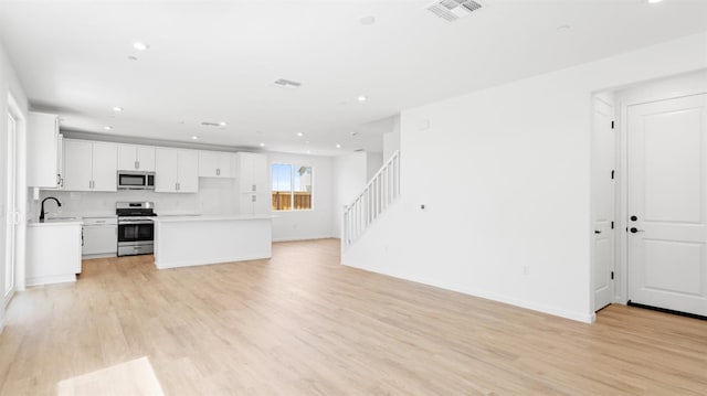 4040 Molten Creek Way, Roseville, CA 95747 - unfurnished living room with light wood-type flooring, recessed lighting, and stairs