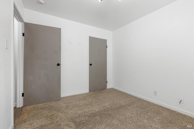 unfurnished bedroom featuring baseboards and carpet