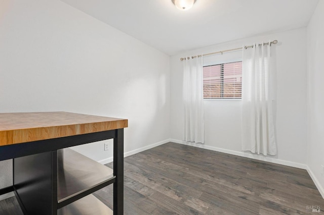 unfurnished room featuring dark wood finished floors and baseboards