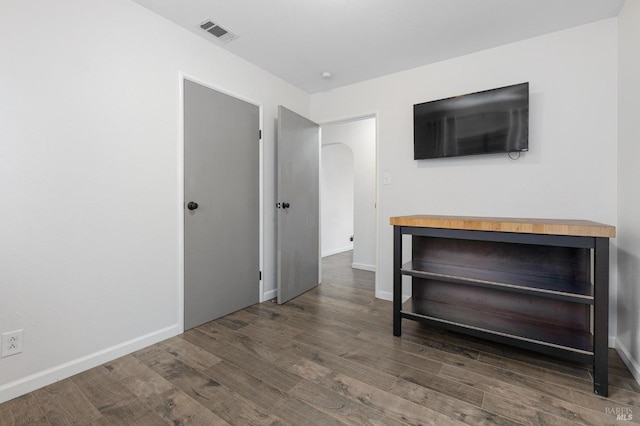 empty room with visible vents, baseboards, and wood finished floors