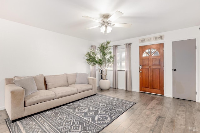 living room with wood finished floors, baseboards, and ceiling fan