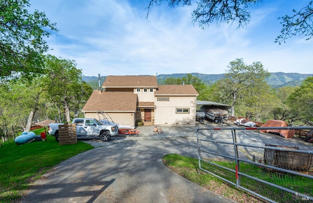 view of front of house featuring a mountain view, fence, a shingled roof, and stucco siding