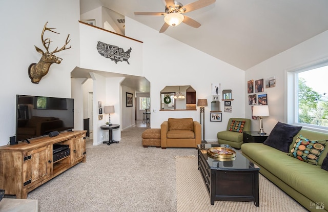 living room featuring ceiling fan, high vaulted ceiling, and light carpet