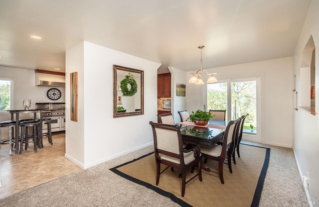 dining space with a wealth of natural light, light colored carpet, and baseboards