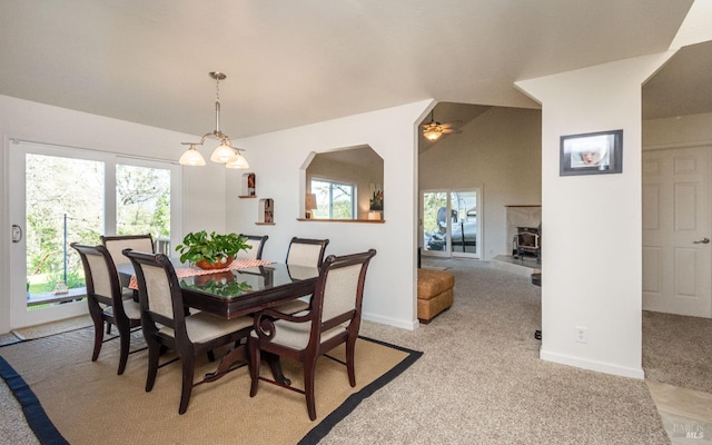 dining room with a wealth of natural light, baseboards, light carpet, and vaulted ceiling