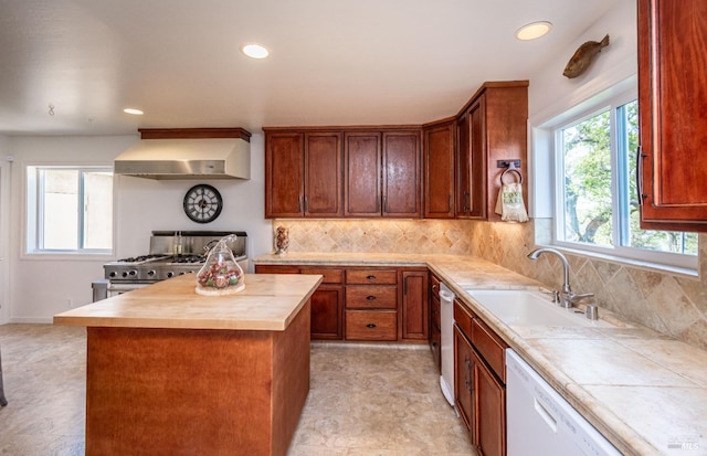 kitchen featuring gas stove, a sink, decorative backsplash, dishwasher, and wall chimney exhaust hood