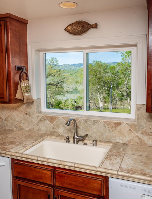 kitchen featuring a sink, plenty of natural light, dishwasher, and light countertops