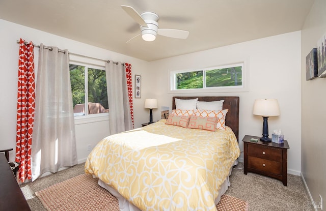 bedroom featuring multiple windows, light colored carpet, and baseboards