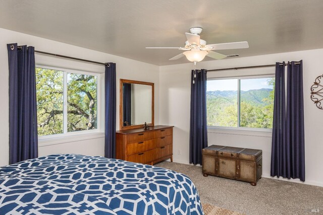 bedroom with visible vents, multiple windows, carpet, and ceiling fan