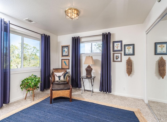 sitting room featuring baseboards, visible vents, and carpet floors