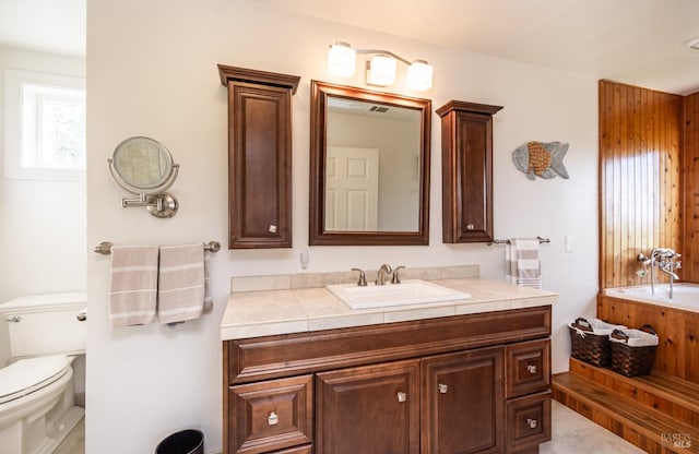 full bath with toilet, vanity, and a washtub