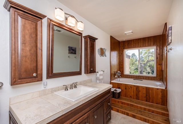 full bathroom featuring a bath, visible vents, tile patterned floors, and vanity