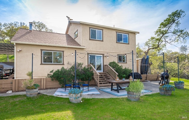 back of property featuring stucco siding, a patio, a lawn, and roof with shingles