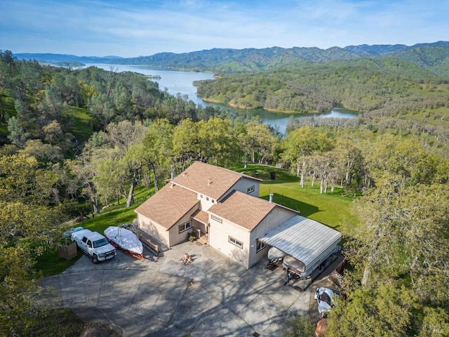 drone / aerial view with a forest view and a water and mountain view