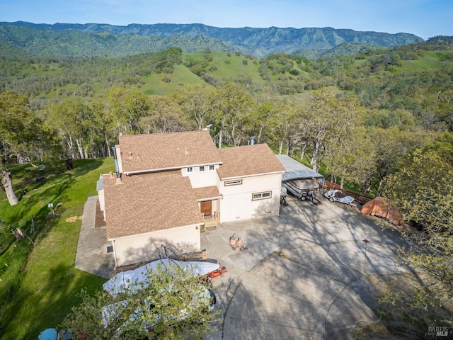 birds eye view of property featuring a mountain view and a view of trees