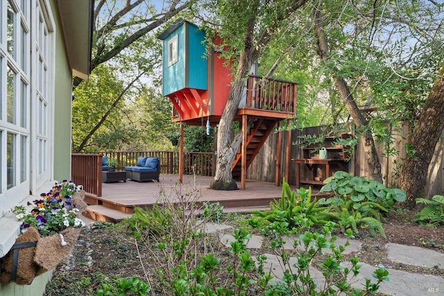 view of playground with an outdoor living space, a wooden deck, and fence