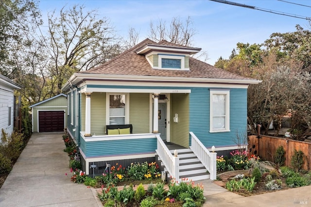 view of front of property with fence, a porch, a shingled roof, an outdoor structure, and a garage