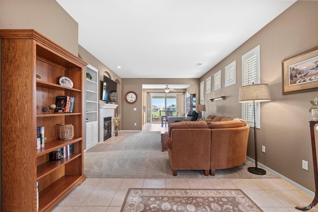 living room with a fireplace with flush hearth, light colored carpet, visible vents, and light tile patterned floors