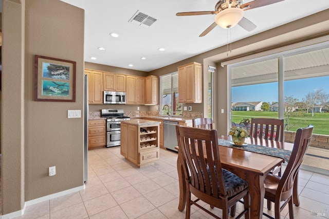 kitchen with light tile patterned floors, light brown cabinets, visible vents, a sink, and appliances with stainless steel finishes