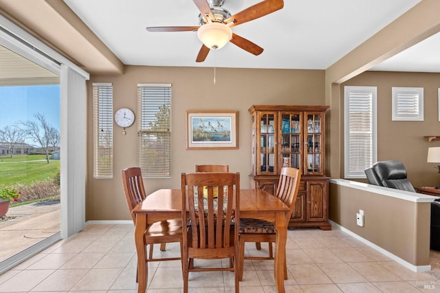 dining room with light tile patterned floors, baseboards, and ceiling fan