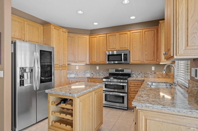 kitchen with light tile patterned floors, light stone countertops, a sink, light brown cabinetry, and stainless steel appliances