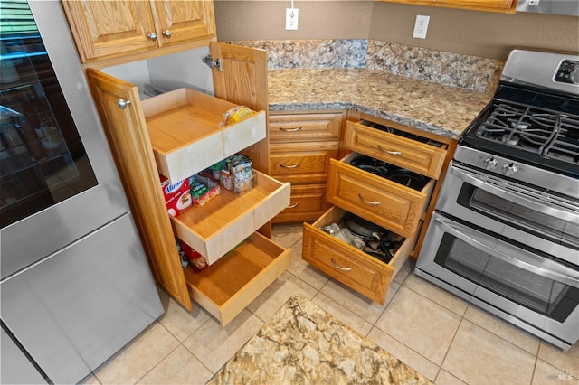 kitchen featuring light tile patterned floors, double oven range, and light stone countertops