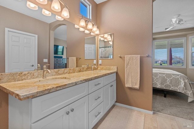 full bathroom with tile patterned flooring, double vanity, baseboards, and a sink