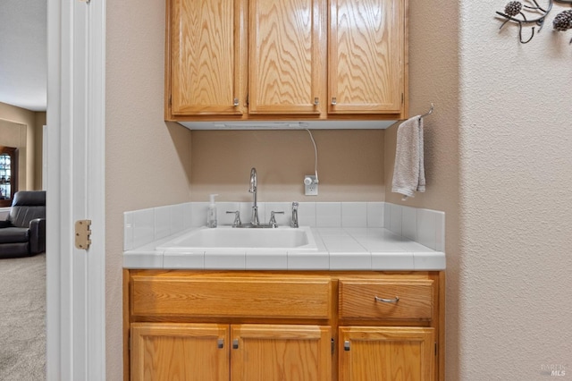 washroom featuring a textured wall and a sink