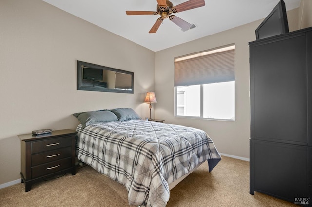 bedroom featuring light carpet, a ceiling fan, and baseboards